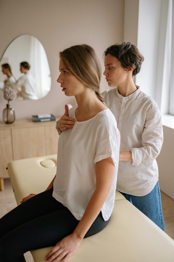 Service-3-min Two women engaging in a therapeutic physical therapy session in a serene indoor setting.